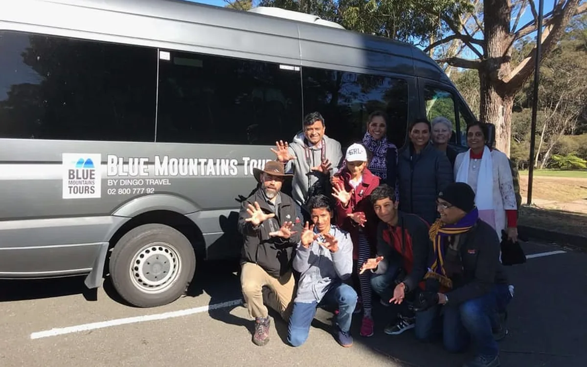 A small tour group beside a minibus in the Blue Mountains