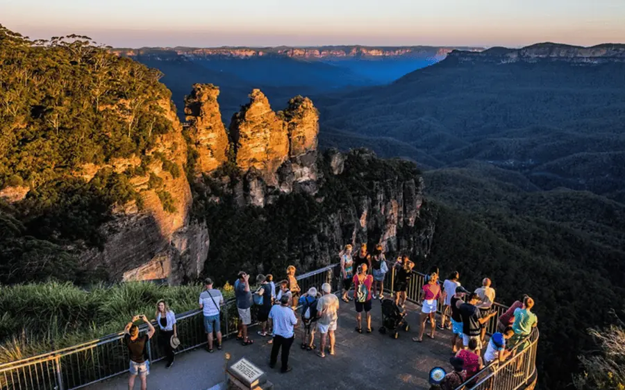 Visitors at Echo Point at dusk with the Three Sisters behind